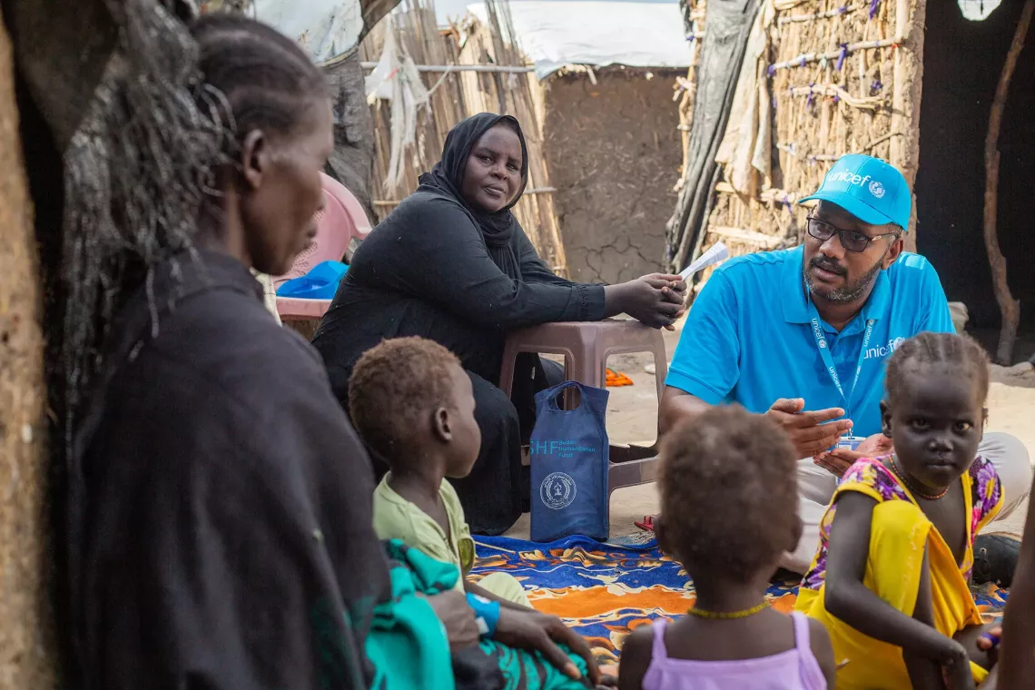 2023年8月24日，苏丹，一名联合国儿童基金会工作人员在家庭走访时与一位母亲交谈。