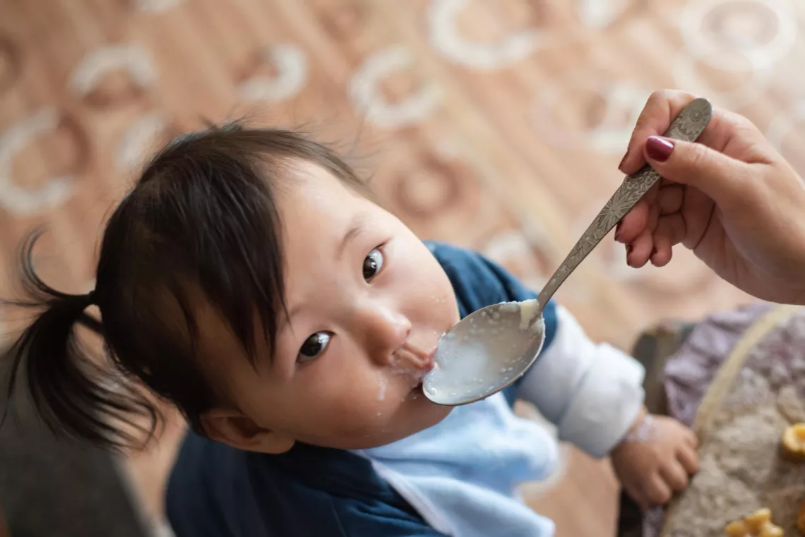 2018年9月7日，一位母亲正在喂孩子加入了微量营养元素粉的粥。