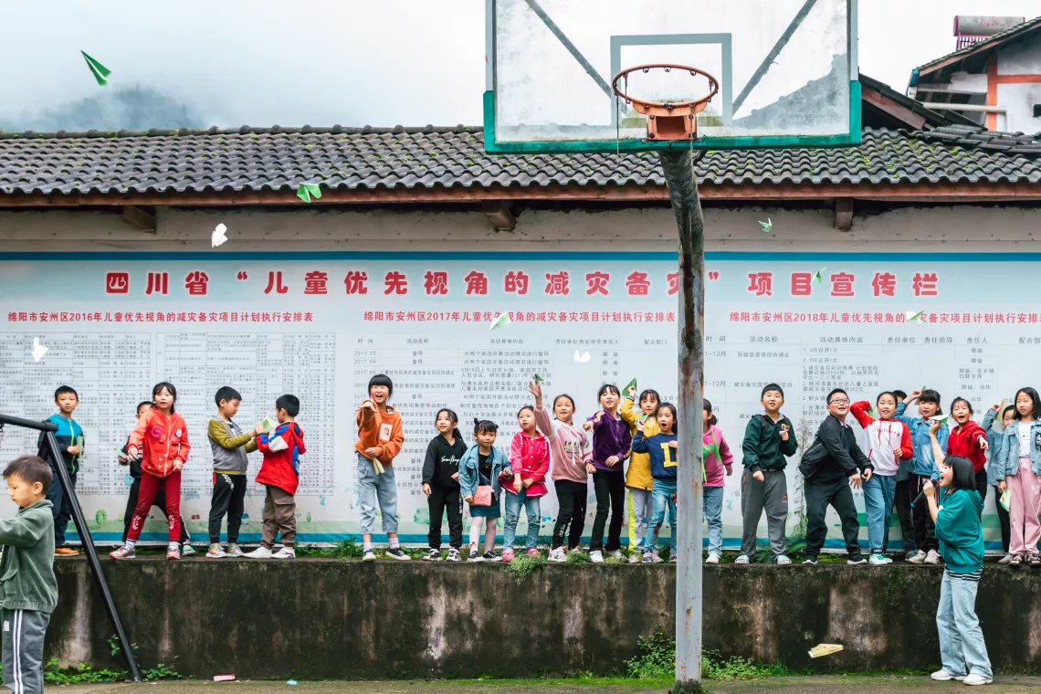 Lamei helps the staff of child-freindly space organize games at the child-freindly space of Qianfo Town, Sichuan Province.