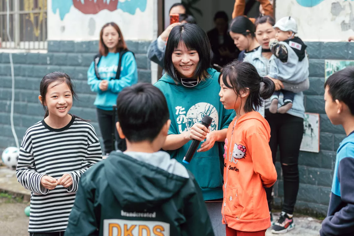 在四川千佛镇儿童友好家园，腊梅协助工作人员组织游戏。
