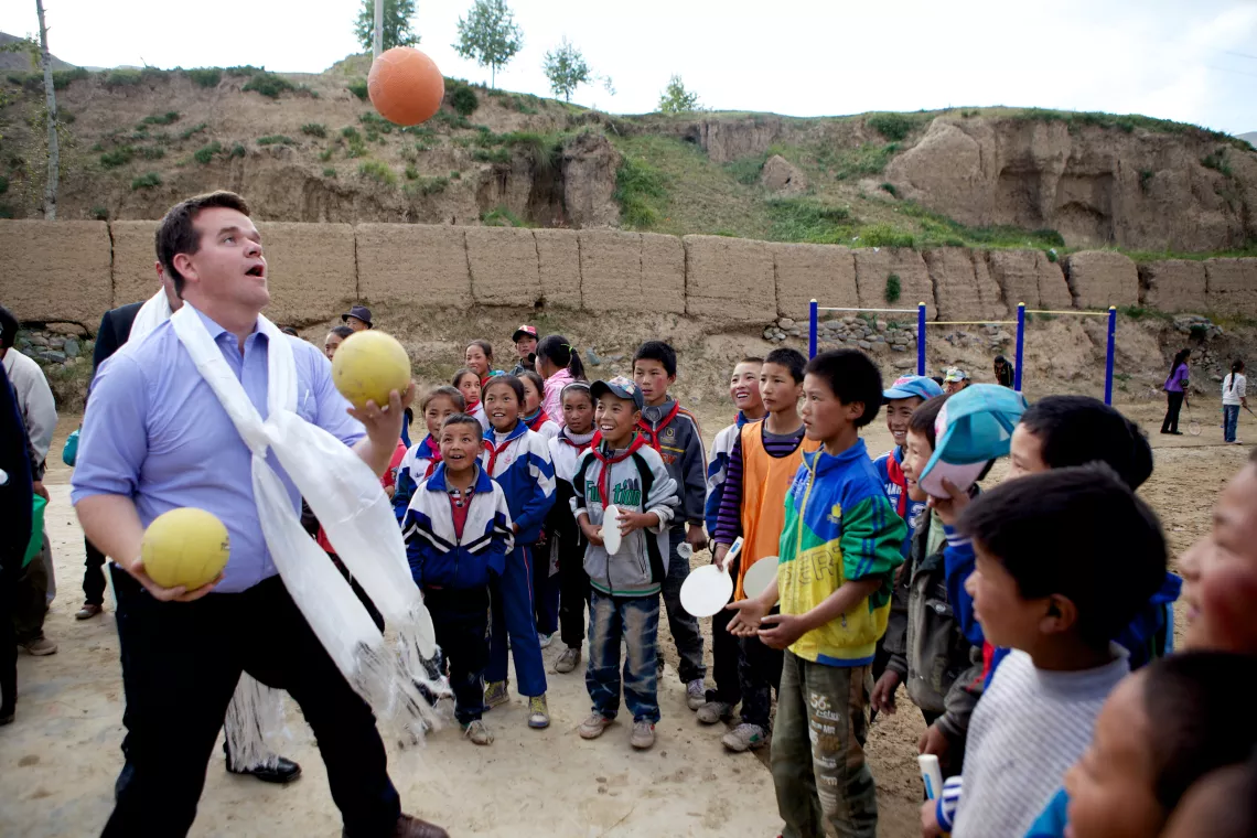 Stefan Stefansson of the Icelandic National Committee deftly juggles three volleyballs to a crowd of awe-struck Tibetan boys.