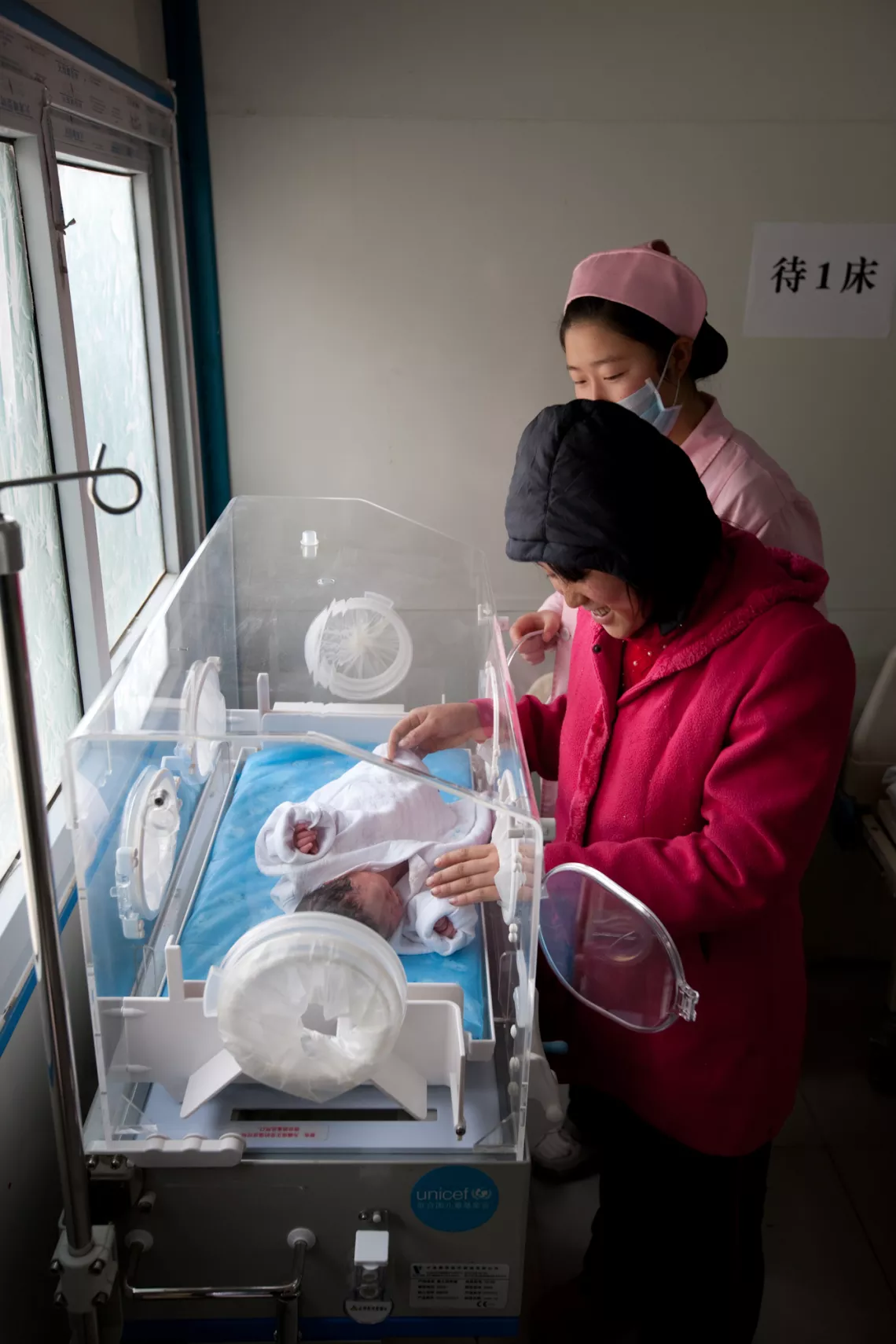 在专业护士的陪伴下，张成美第一次抚摸着宝宝的小脸蛋、小手和小脚丫。