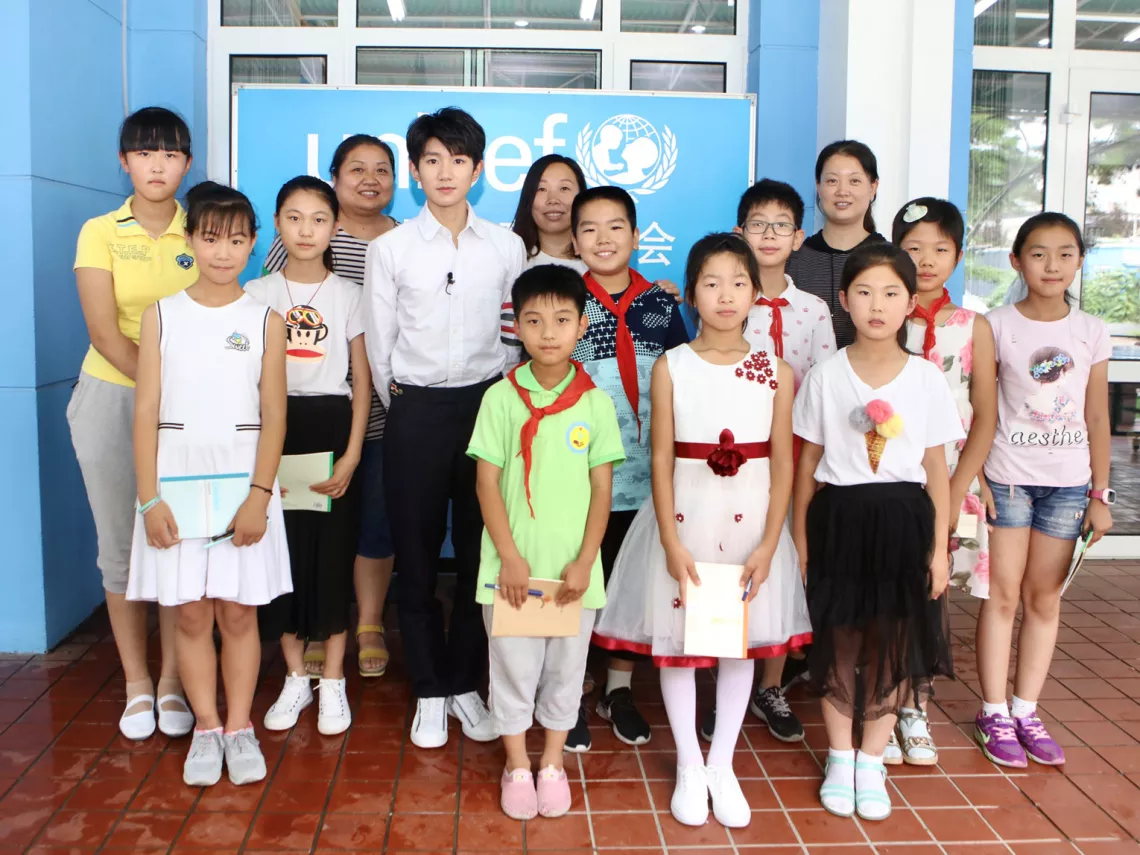Wang Yuan takes a group photo with the children and their teachers.