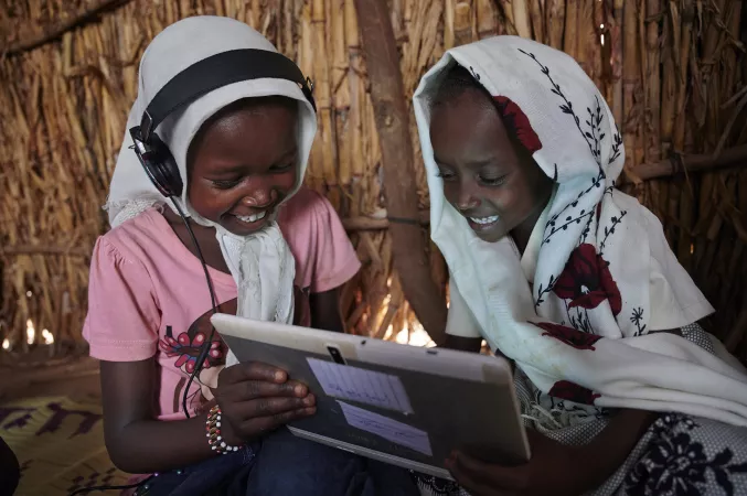 苏丹东部地区的孩子们在联合国儿童基金会支持的电化教育中心内共同使用平板电脑学习。