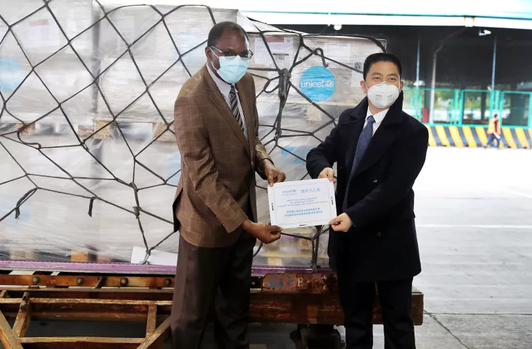Jacob Mbeya, UNICEF Deputy Representative to China, presents a certificate of supplies to Xu Xingfeng, Deputy Commissioner of the Commissioner’s Office in Shanghai under the Ministry of Commerce, at the cargo area of Pudong International Airport in Shanghai on 29 January 2020.