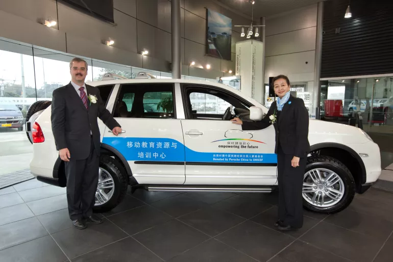 2009年12月7日，保时捷（中国）汽车销售有限公司首席执行总裁柏涵慕先生（左）向联合国儿童基金会驻华代表魏英瑛博士（右）交付“移动教育资源与培训中心”项目用车。
