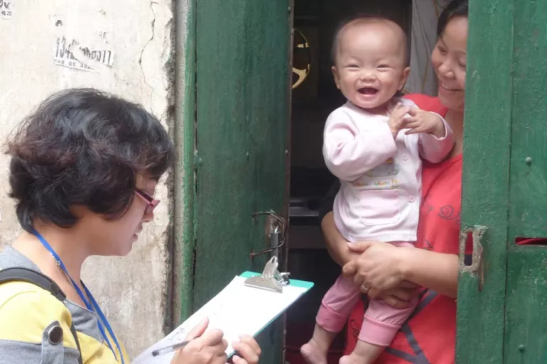 A member of the survey team interviews a mother and her baby for the maternal and neonatal tetanus validation.