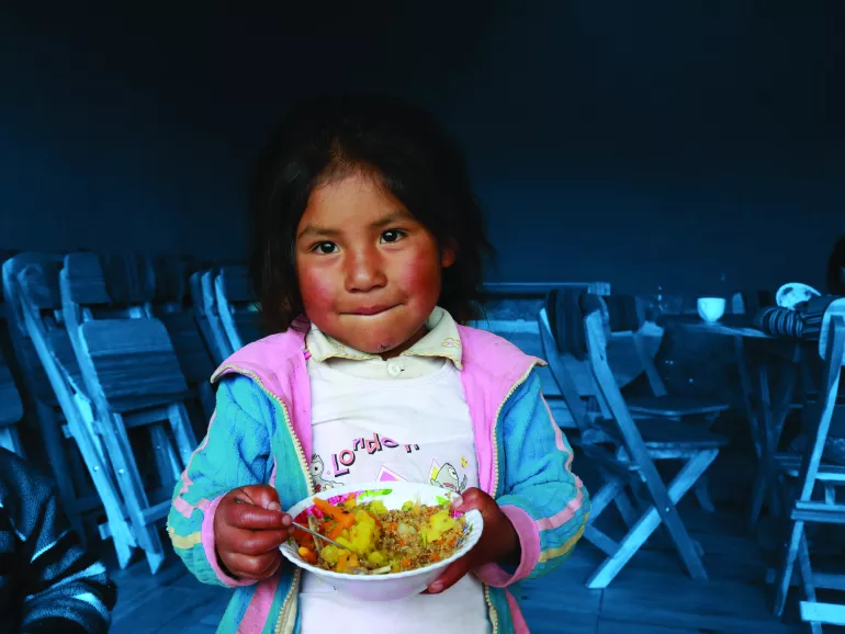 A girl eats lunch in the Hanaq Chuquibamba community in Peru.