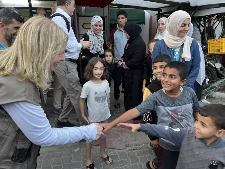 联合国儿童基金会执行主任凯瑟琳·拉塞尔与一名加沙当地儿童握手。