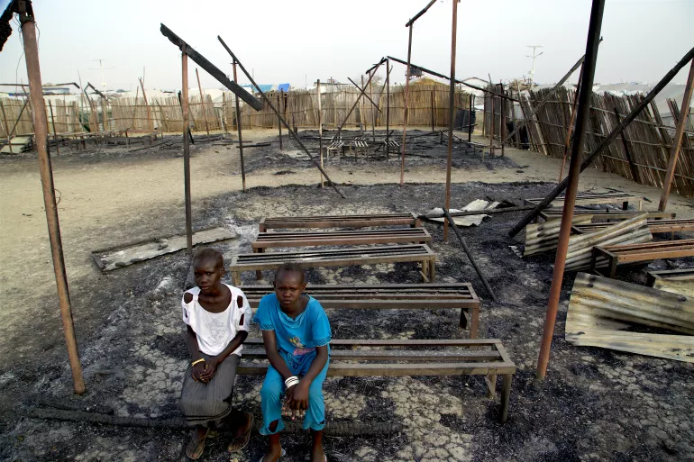 On 3 March 2016 in South Sudan, Chubat (right), 12, sits with her friend in the burned ruins of her school in Malakal Protection of Civilian site.