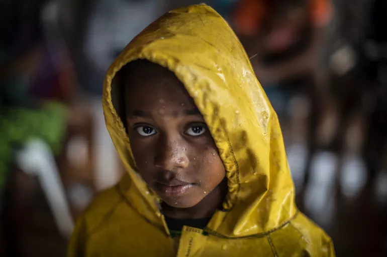 2020年11月16日，飓风约塔自尼加拉瓜比尔维过境后，一名女孩从避难所返回家中时穿着雨衣避雨。