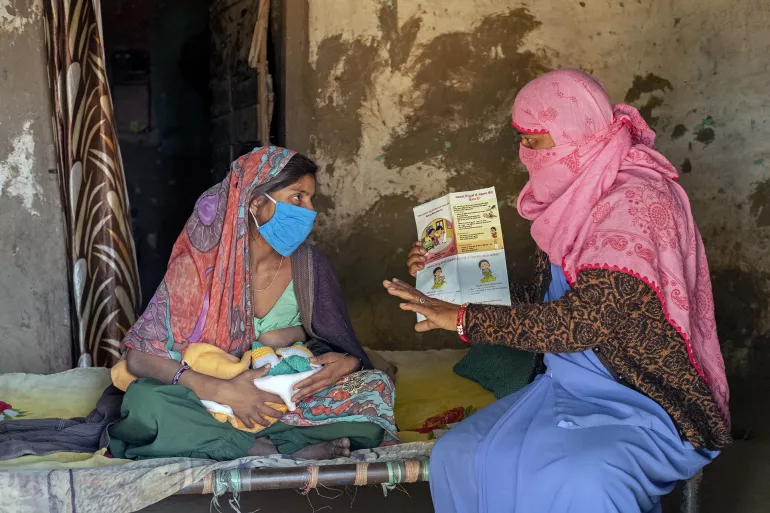 在印度，34岁的社会工作者Reena Patidar（右）向年轻母亲讲述母乳喂养的重要性。 