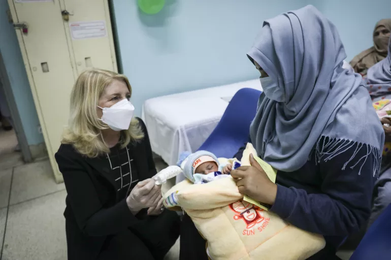 2022年2月22日，在伊斯兰堡巴基斯坦医学研究所(PIMS)新生儿科的健康教育室，联合国儿童基金会执行主任凯瑟琳·拉塞尔(左)与苏美拉交谈，苏美拉怀里抱着她尚未取名的宝宝。在这个健康教育室里，母亲们被教授如何进行纯母乳喂养以及个人卫生、与新生儿的皮肤接触和常规免疫的重要性。