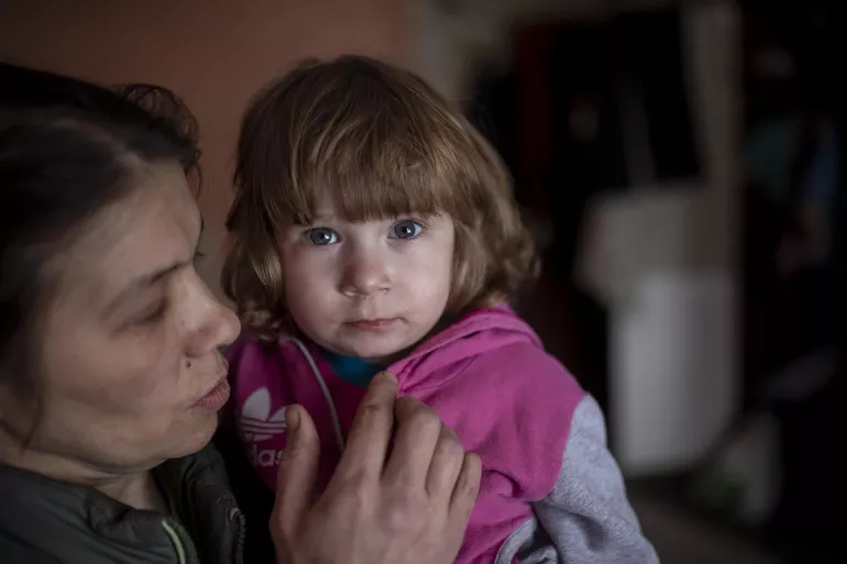 乌克兰东部的一名妇女抱着年幼的女儿。