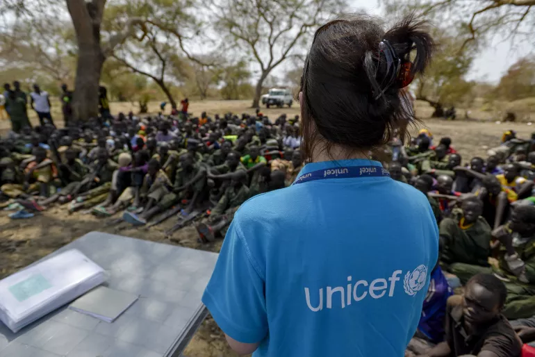 A UNICEF worker stands in front of a group of children undergoing release from the South Sudan Democratic Army Cobra Faction armed group in Pibor, Jonglei State.