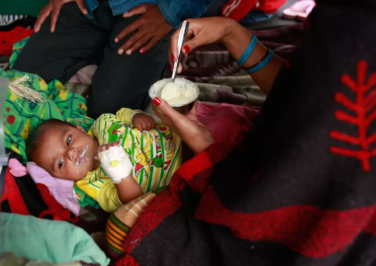 4月26日，在首都加德满都的特里布万医科学院，一位妇女给在大地震中受伤的婴儿喂食。