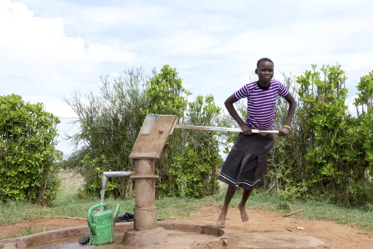 在乌干达东北部，一名女孩从钻井中泵水。