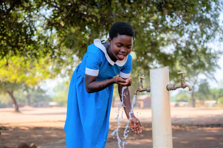 诺利亚.卡尼亚玛（Noriah Kanyama）在马拉维的一所学校里用联合国儿童基金会支持安装的水龙头喝水。
