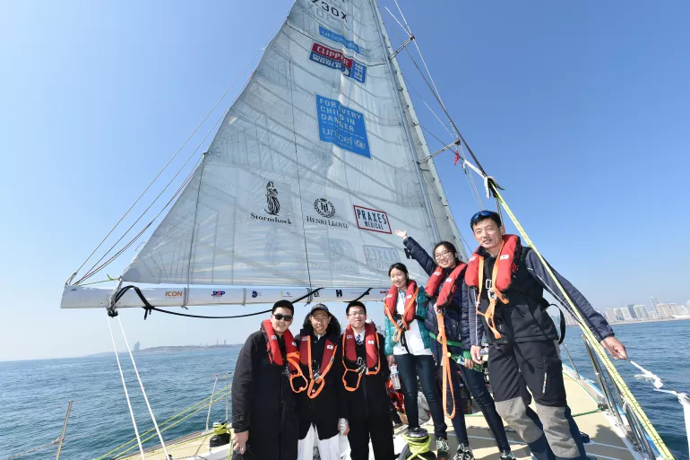 参加克利伯环球帆船赛的船员代表和中国青少年在联合国儿童基金会号上合影。