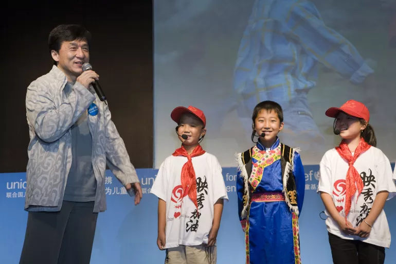 联合国儿童基金会亲善大使成龙先生与来自四川灾区的孩子们在台上互动。