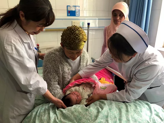 Medical staff talk with a mother who has received early essential newborn care (EENC) in the People's Hospital of Hongsipu District in Wuzhong City, northwest China's Ningxia Hui Autonomous Region.